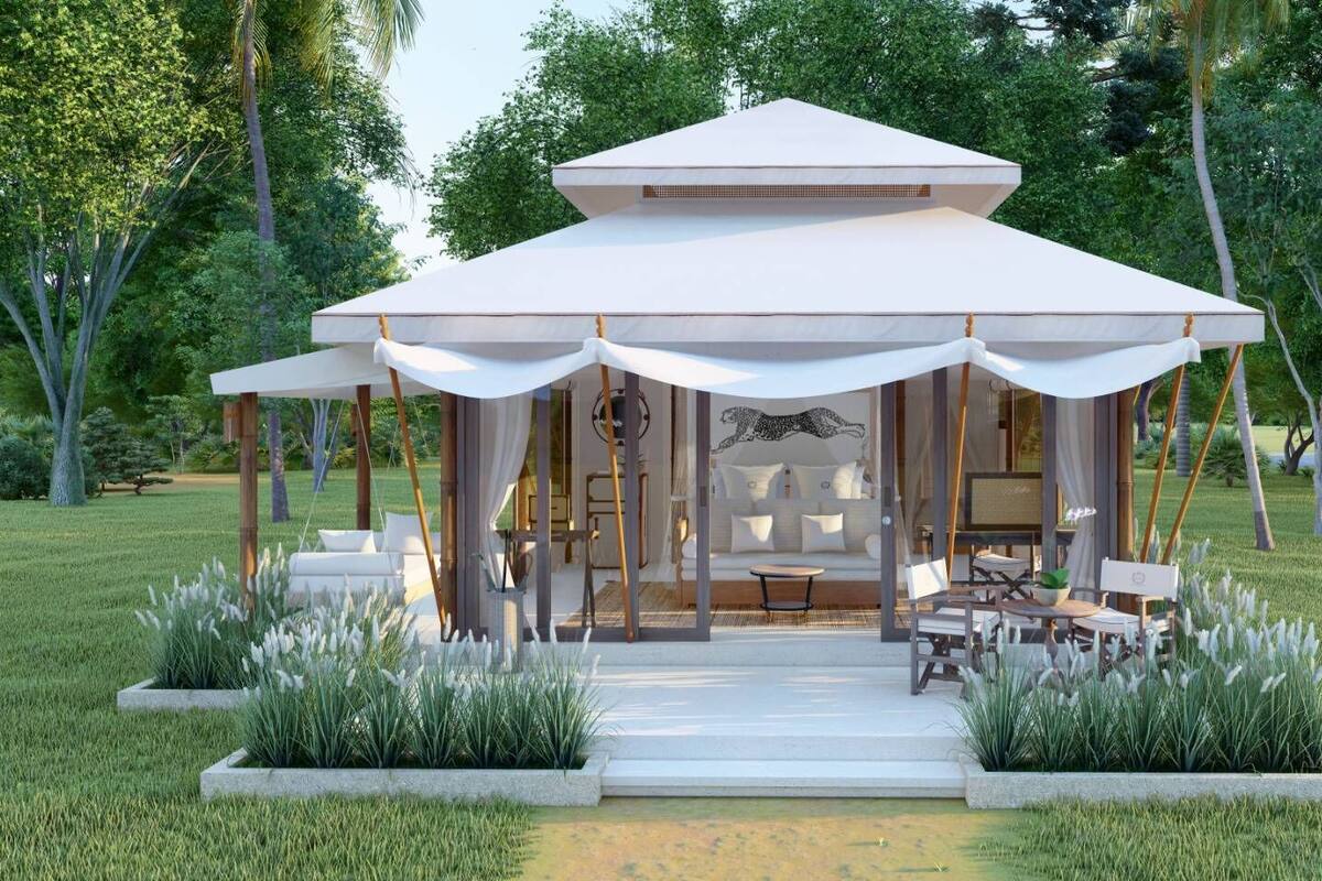 A modern outdoor pavilion with a covered seating area, surrounded by lush greenery and a well-maintained lawn.