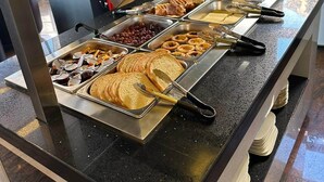 A buffet with various food items including bread, pastries, and fruits. - Hotel white swan (Wormeldange)