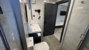 A modern bathroom with a glass shower enclosure, a white sink, and a toilet. - Rota Bozcaada (Bozcaada)
