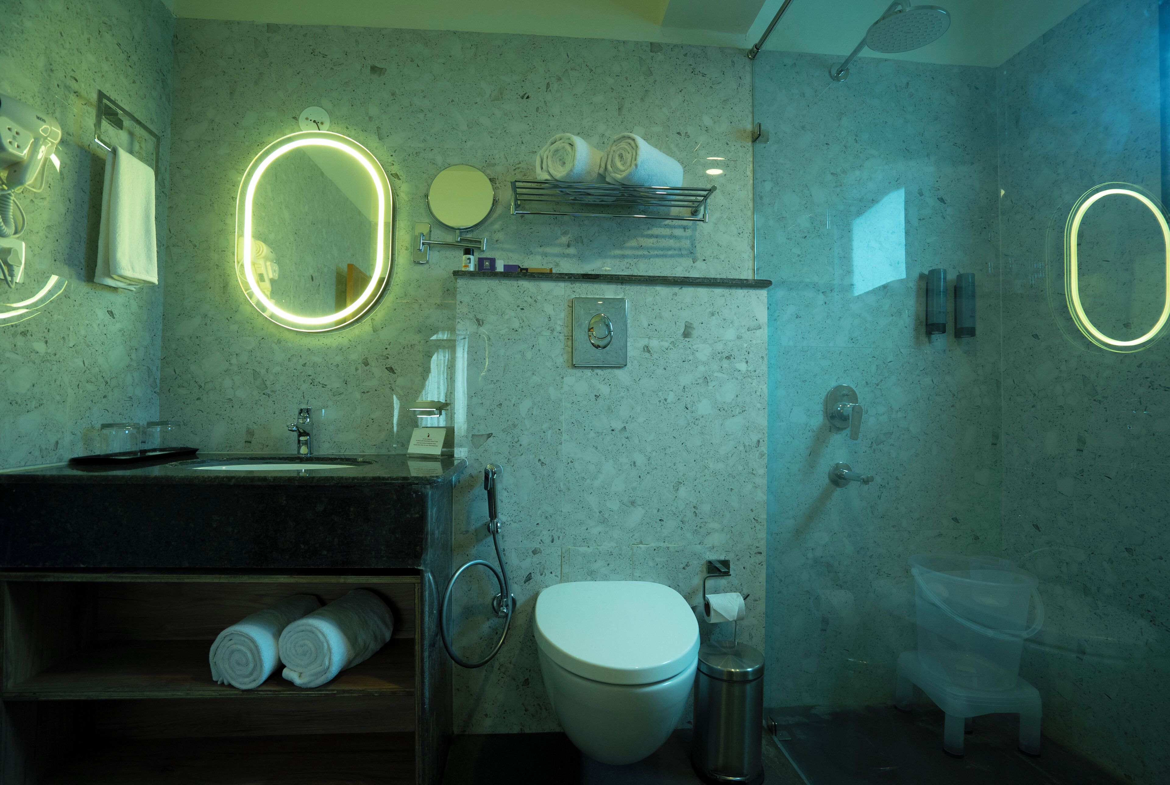 A modern bathroom with a sink, mirror, toilet, and shower.