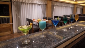 Eine Barbereich mit einer Granit-Arbeitsplatte und einer Reihe bunter Cocktails.