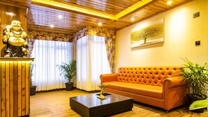 Una habitación con techo de madera, un sofá, una mesa de centro, una estatua y un cuadro.