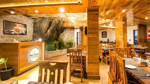 Un interior de restaurante con decoración de madera, una pared de piedra y una recepción.