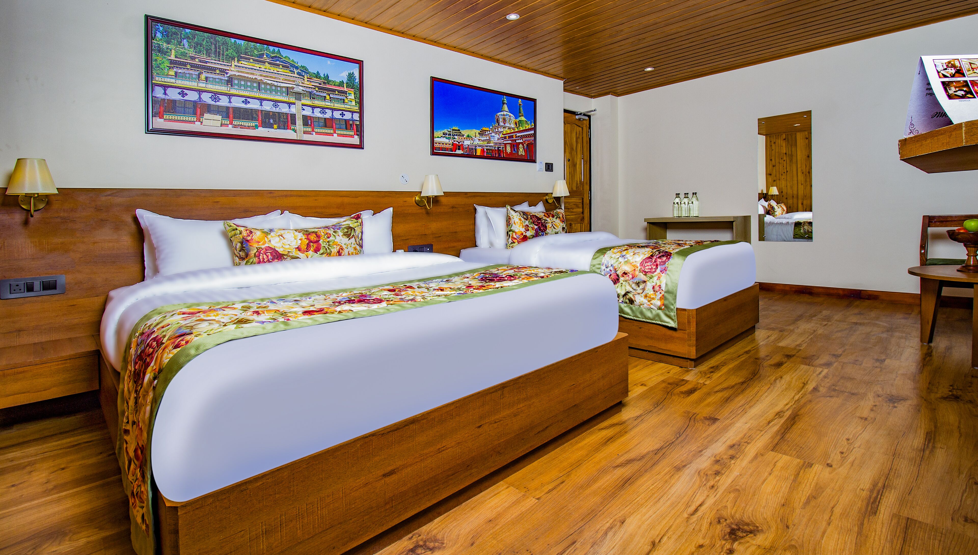 Habitación de hotel con dos camas, cabeceros de madera y un cuadro grande de un edificio tradicional en la pared.