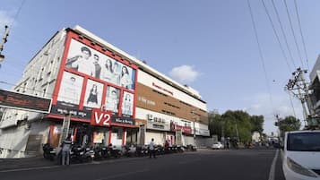 A street view with a building featuring a large advertisement and several shops.