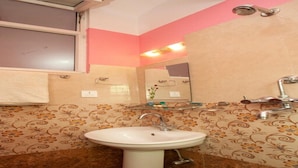 Un baño con lavamanos, espejo y toallero.