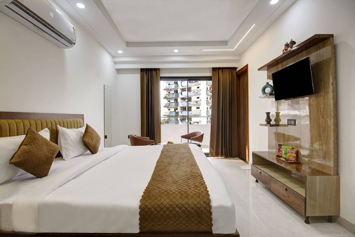 A modern hotel room with a large bed, a TV, a wooden cabinet, and a view of the city.