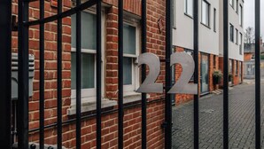 Een gebouw met een bakstenen gevel en een zwart metalen hek.