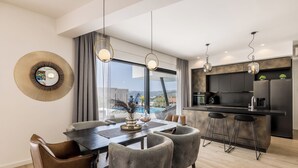 Una cocina moderna con una isla grande, taburetes de bar y un comedor con mesa y sillas.