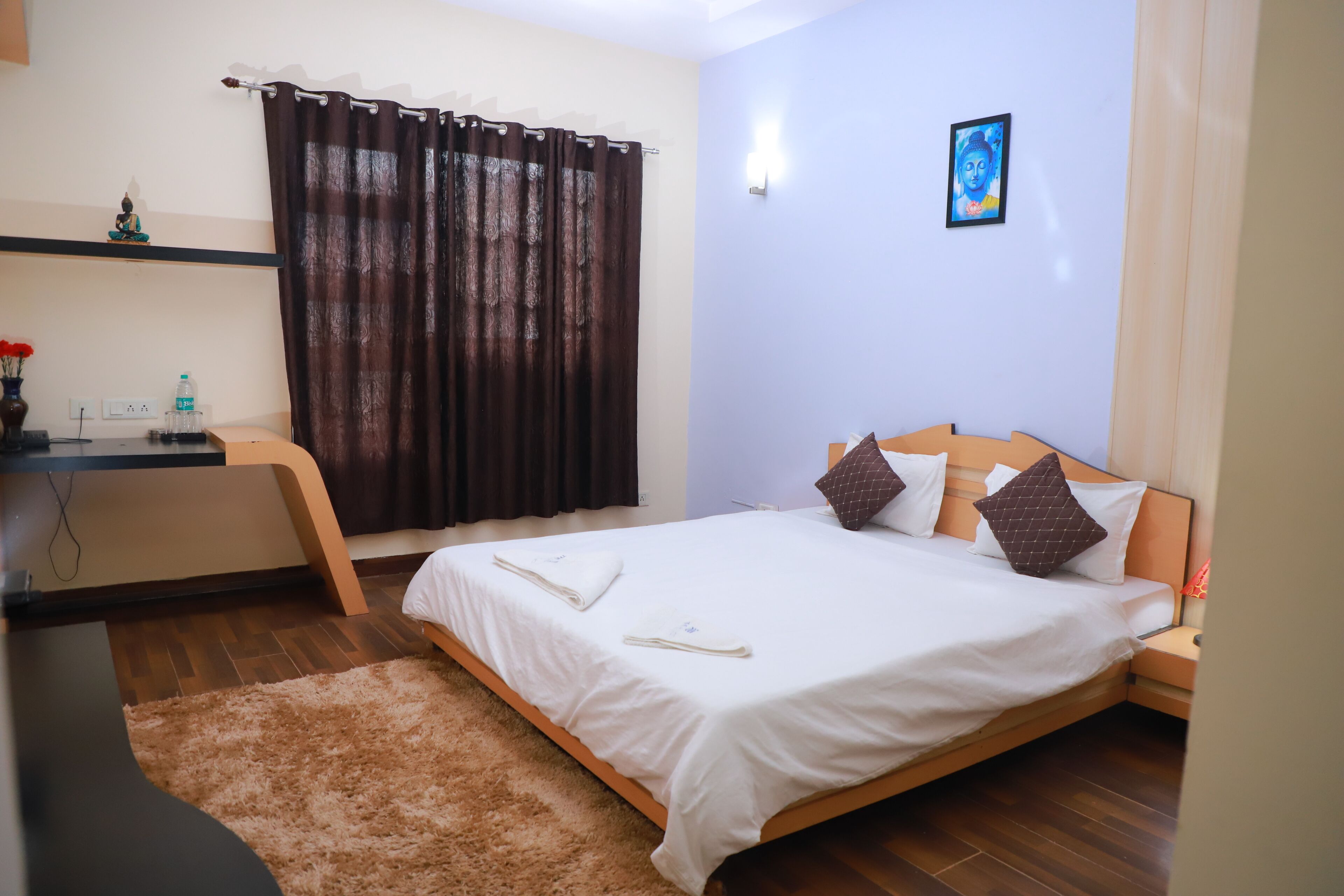 Un dormitorio ordenado con cama, mesita de noche y escritorio con silla.