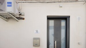 En bygningseingang med en dør, et nummer og en klimaanlæg.
