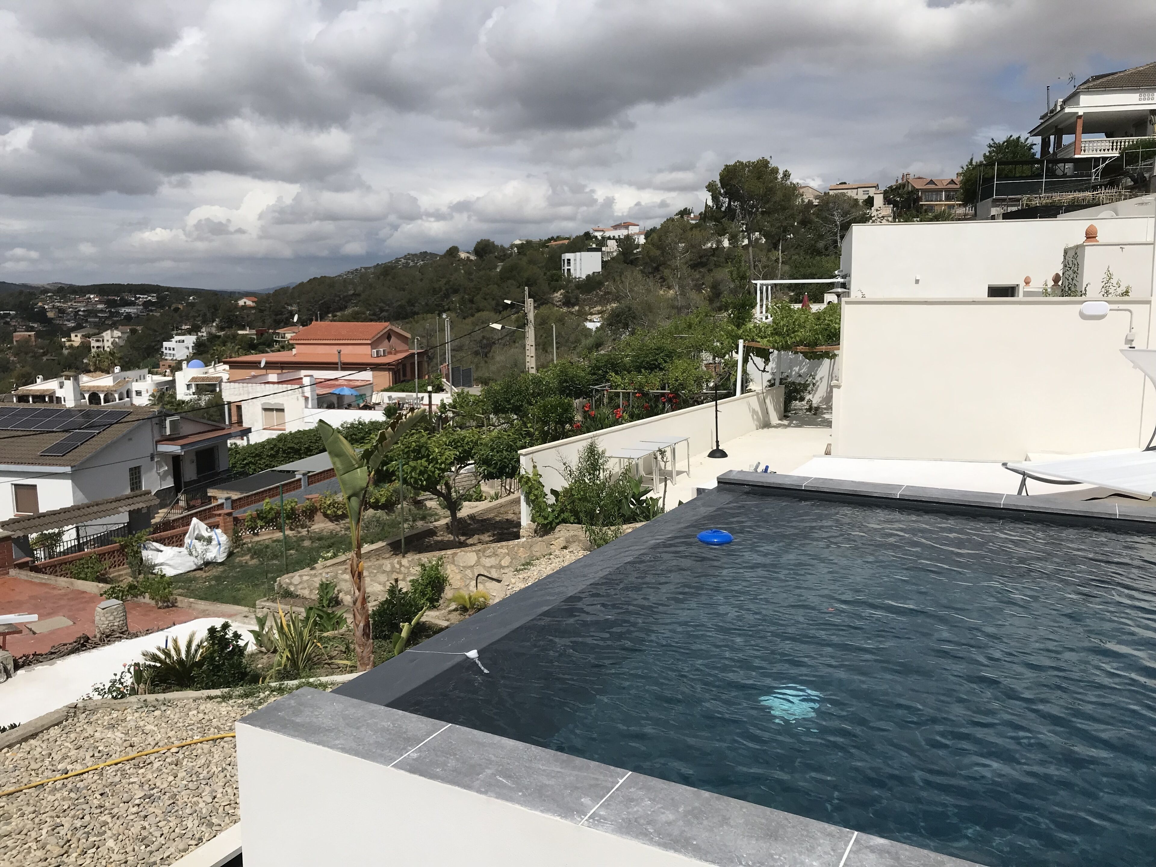 A rooftop pool with a clear view of the surrounding neighborhood, including houses and trees.