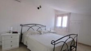 Ein Schlafzimmer mit einem Bett, einem Nachttisch und einem Kleiderschrank.