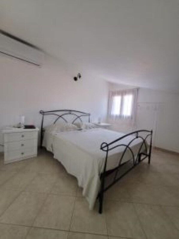 A bedroom with a bed, a bedside table, and a wardrobe.
