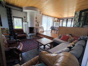 A living room with a fireplace, leather sofas, a dining area, and large windows. - A 3 min du Parc de Sainte-croix de Rhodes! Grand Gîte Familial, Avec Aire de jeu (Rhodes)