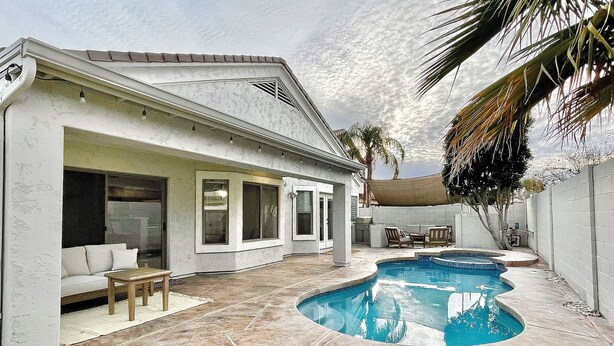A house with a swimming pool, a patio with a sofa and table, and a covered outdoor area. - Private and Charming Vacation Home near Downton Gilbert - Pool/hot tub/fireplace (Gilbert)