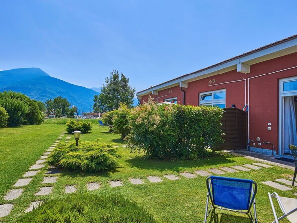 Un bâtiment rouge avec un chemin de jardin qui mène à une chaise bleue.