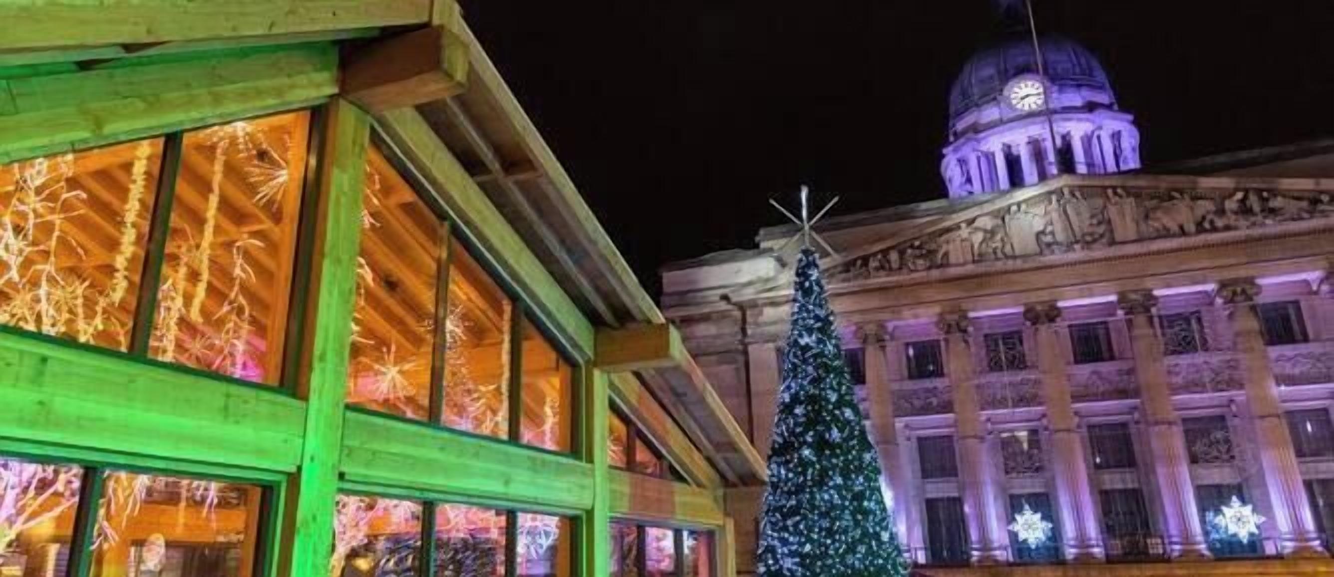 Un bâtiment doté de grandes fenêtres et d’un sapin de Noël.