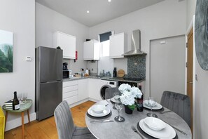 A modern kitchen with white cabinets, a stainless steel refrigerator, and a granite countertop. - Central 1-Bed Near Market Square (Nottingham)