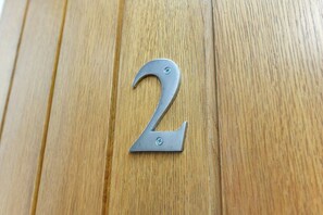 A metallic number '2' sign on a wooden surface. - Central 1-Bed Near Market Square (Nottingham)