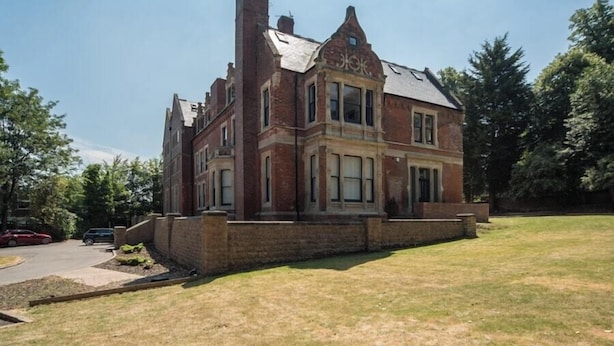 A large, two-story brick building with a prominent corner entrance and a small front porch. - Wow! 1bed Stunning Apt in Victorian Mansion (Nottingham)
