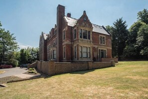A large, two-story brick building with a prominent corner entrance and a small front porch.