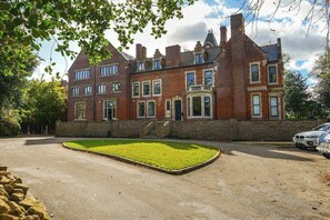 A large, multi-story brick building with a central entrance and a well-maintained lawn. - Wow! 1bed Stunning Apt in Victorian Mansion (Nottingham)