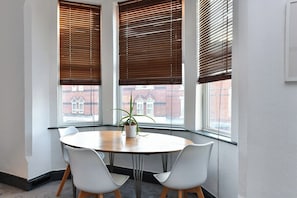 A conference room with a round table, two white chairs, and a potted plant. - 5-BR Home Featuring Art and Photography Collection (Nottingham)