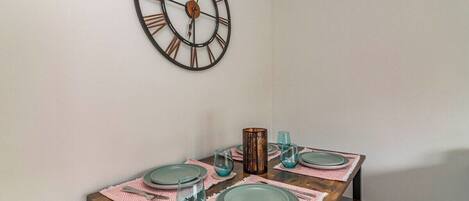 A dining table set with plates, glasses, and a candle.