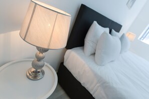 Cozy retreat with a comfortable bed and a stylish nightstand.