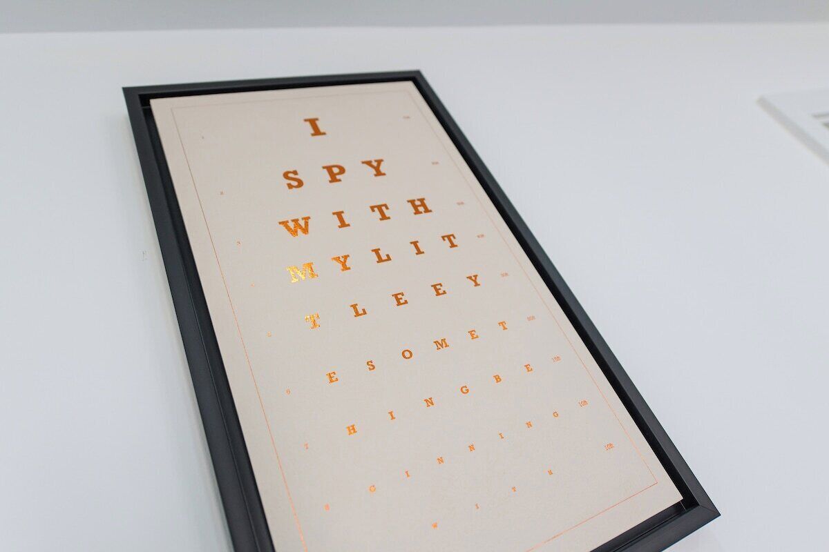 A framed text with the phrase 'I SPY WITH MY EYES' in a serif font.