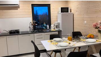 Una cucina compatta con zona pranzo, dotata di forno a microonde, macchina del caffè e un'ampia finestra con vista panoramica.