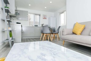 A modern living room with a marble coffee table, grey sofas, and a yellow patterned pillow. - 2-BR Flat w/ Free Parking Near Nottingham (Gedling)
