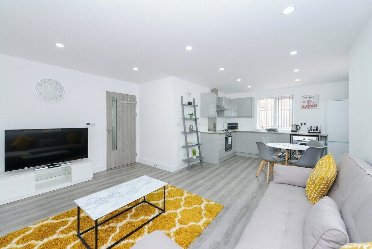 A modern living room with a TV, sofa, and coffee table.