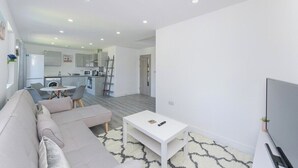 A modern living room with a sofa, a coffee table, and a TV. - 2-BR Stay w/ Parking Near Nottingham (Carlton)
