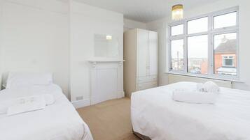 Une chambre d’hôtel avec deux lits, une armoire, un miroir et une fenêtre donnant sur un paysage agréable.