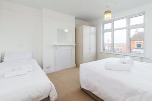 Une chambre d’hôtel avec deux lits, une armoire, un miroir et une fenêtre donnant sur un paysage agréable.
