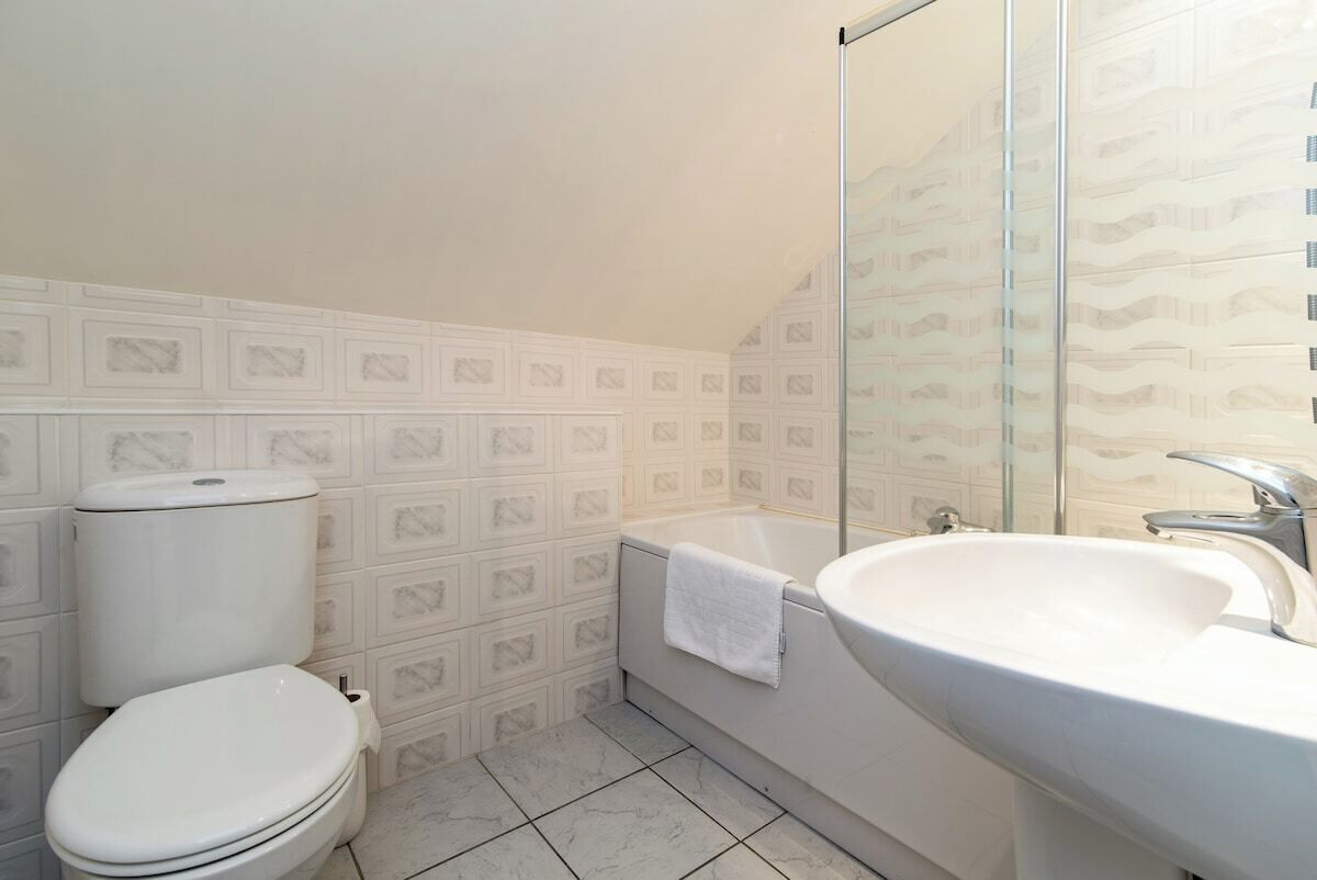 Un baño con inodoro, bañera y lavamanos.