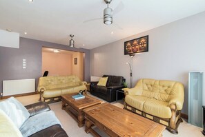 Un salon avec deux canapés, une table basse et un lampadaire.