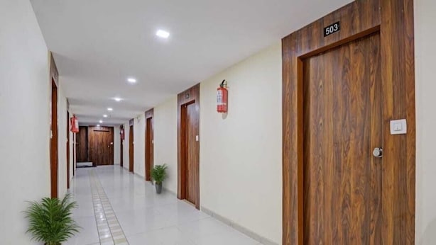 A hotel corridor with wooden doors, numbered 503, and a fire extinguisher on the wall. - Hotel Neelkamal (Ahmedabad)