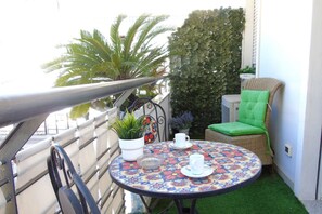 A small outdoor balcony with a round table, two chairs, a potted plant, and a decorative wall. - Homiday - B&B Meraviglie d'Abruzzo (Cellino Attanasio)