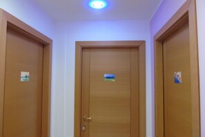 A hallway with three wooden doors, each with a small label. - Homiday - B&B Meraviglie d'Abruzzo (Cellino Attanasio)