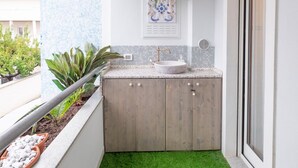 A small bathroom with a wooden vanity, a sink, and a potted plant. - Homiday - B&B Meraviglie d'Abruzzo (Cellino Attanasio)