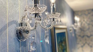 Un lustre mural agrémenté de détails en cristal et équipé de deux ampoules.