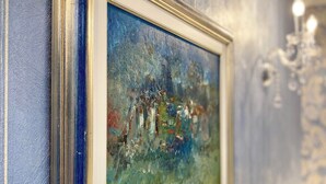 Un tableau encadré est accroché à un mur bleu à la texture particulière.