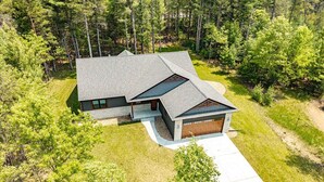 A modern two-story house with a sloped roof, a garage, and a well-maintained lawn.