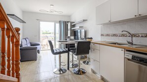 Eine moderne Küche mit Essbereich, einer Couch und einer Treppe.