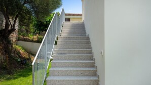 A staircase with a metal railing leading to a building with a tiled roof. - Sardegna è - New rooms (Olbia)