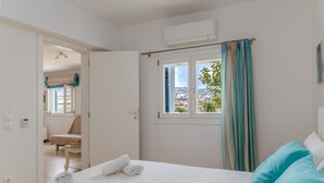 Une chambre d’hôtel avec un lit, une fenêtre avec des rideaux, une chaise et une vue sur l’extérieur.