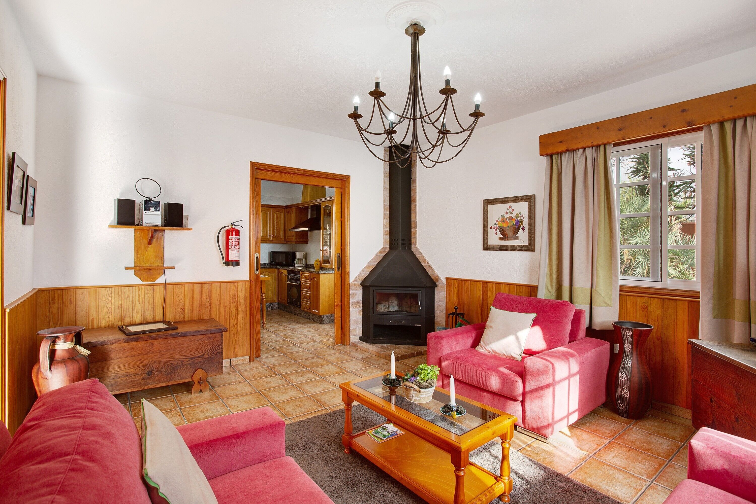 A living room with a fireplace, a chandelier, a sofa, and a coffee table. - Holiday Home 'Casa Ariadna' with Sea Views, Private Garden, and Wi-Fi (Tijarafe)